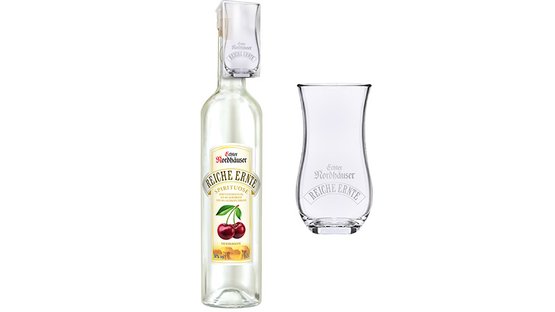Eine Flasche mit klarer Flüssigkeit und einem Glas stehen nebeneinander, beide mit dem Schriftzug 'Echter Nordhäuser'.