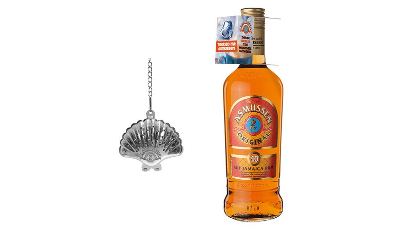 Eine Flasche Asmussen Rum steht neben einem silbernen Teesieb in Muschelform, das an einer Kette hängt.