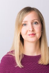 Sabine Pfannmöller: A woman with long, blonde hair and blue eyes wears a purple top and looks directly into the camera.