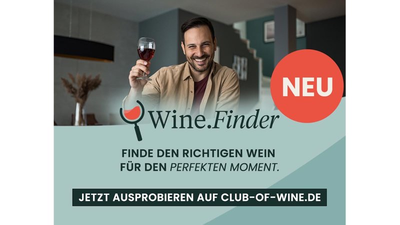 Ein lächelnder Mann hält ein Glas Rotwein in der Hand und genießt den Moment in einem modernen Raum.