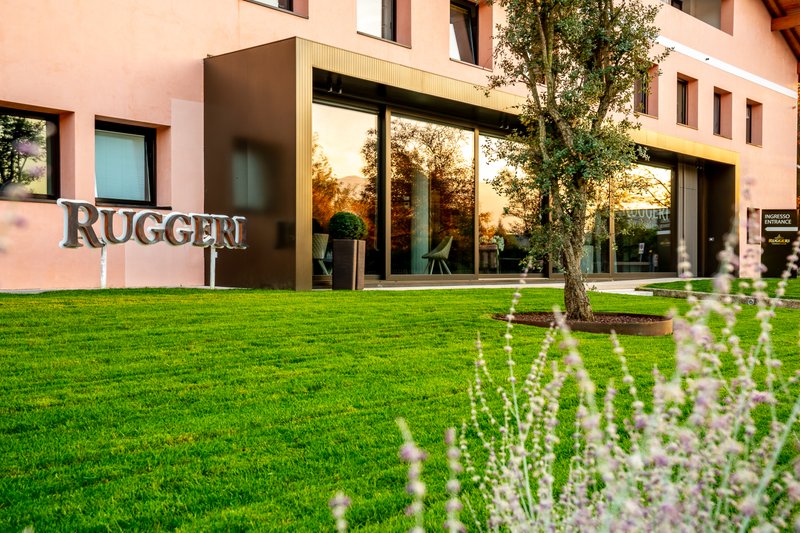 Ein elegantes Gebäude mit dem Schriftzug 'Ruggeri' und einer einladenden Eingangstür, umgeben von gepflegtem Grün.