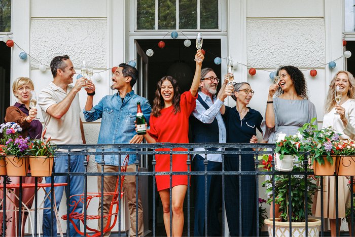 Friends celebrate together on the balcony with champagne and good mood