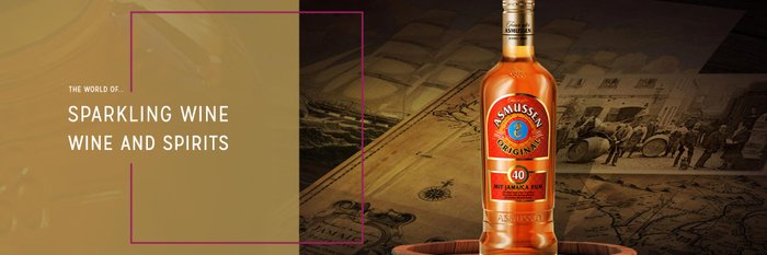 The bottle of Asmussen rum stands out in front of old maps and pictures of historic means of transportation.