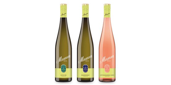 Die Flaschen zeigen eine Auswahl an Mumm Weinen: Riesling, Chardonnay und Spätburgunder Rosé, alle mit eleganten Designs.