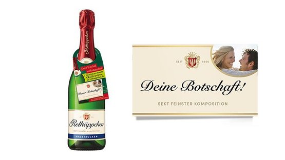Eine Flasche Rotkäppchen Sekt steht neben einer eleganten Karte mit der Aufschrift 'Deine Botschaft!' und einem glücklichen Paar.