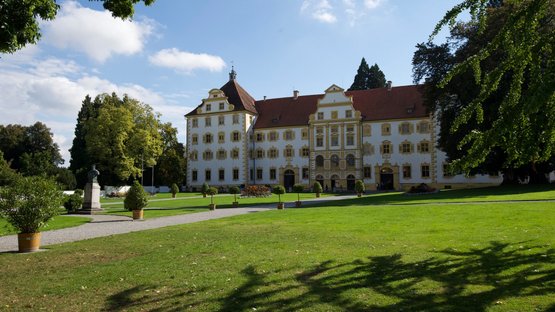 Salem: Ein prächtiges Schloss mit gelben Fensterrahmen und roten Dächern, umgeben von gepflegten Gärten und Bäumen.
