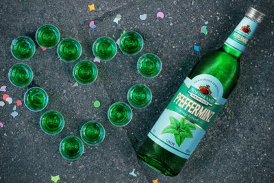 Pfeffi: The green bottle of peppermint liqueur sits next to several shot glasses, while colorful confetti decorates the floor.