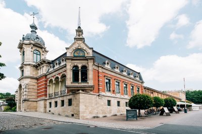 Freyburg: A historic building with an impressive red brick and stone facade, surrounded by trees and a paved path.
