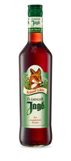 Eine Flasche Fläminger Jagd Kräuterlikör mit einem auffälligen Fuchs-Design auf dem Etikett, umgeben von grünen Kräutern.