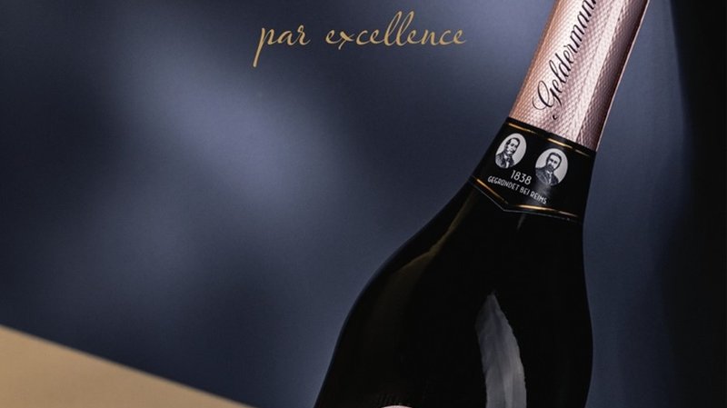 „Flasche Geldermann Rosé Sekt vor dunkelblauem Hintergrund mit goldener Schrift zu traditionellem Handwerk.“