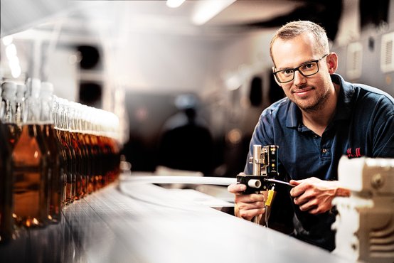 Worker in the beverage bottling plant with bottles