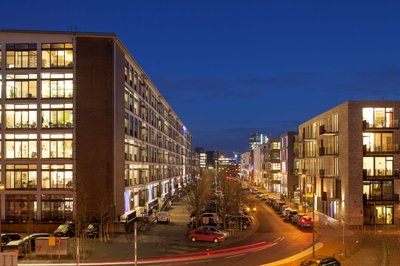 Bremen: A busy street with modern buildings illuminated in the evening creates a lively urban atmosphere.