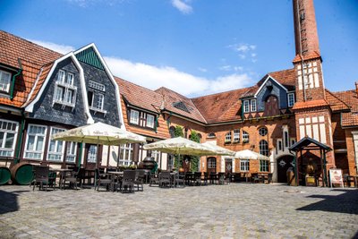 Nordhausen: Ein einladender Innenhof mit Tischen und Stühlen, umgeben von charmanten, historischen Gebäuden und Sonnenschirmen.