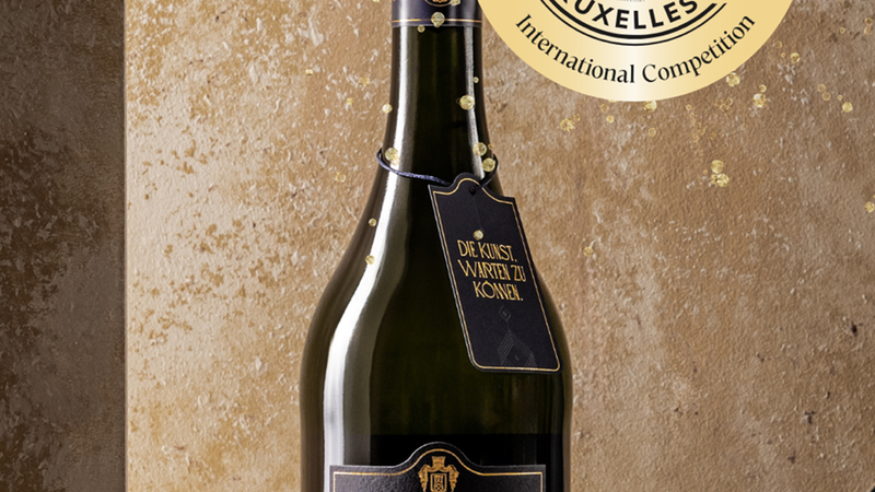 Flasche Geldermann Grande Réserve Sekt vor goldener Wand, ausgezeichnet beim Concours Mondial de Bruxelles