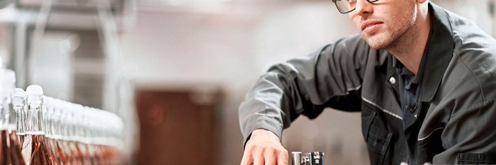 Techniker überwacht die Abfüllung von Flaschen in der Fabrik