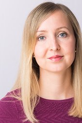Sabine Pfannmöller: A woman with long, blonde hair and blue eyes wears a purple top and looks directly into the camera.