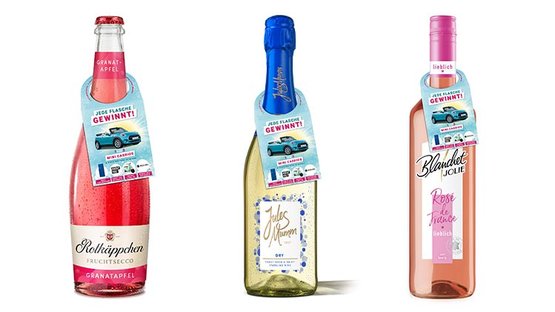 Drei Flaschen mit verschiedenen Getränken stehen nebeneinander, jede mit einem auffälligen Etikett und Gewinnspielhinweis.