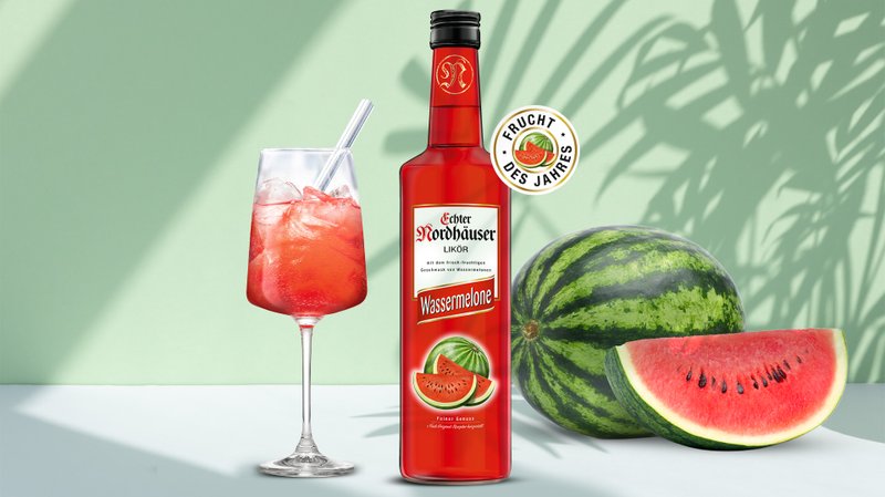Ein erfrischender Wassermelonenlikör steht neben einem Glas mit einem bunten Cocktail und einer frischen Wassermelone.