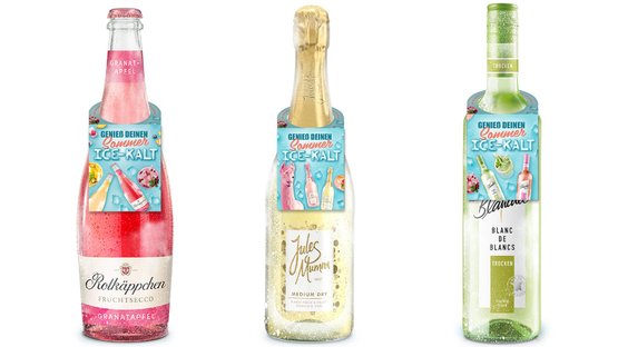 Drei Flaschen Fruchtsecco stehen nebeneinander, jede mit bunten Etiketten und sprudelndem Inhalt, ideal für den Sommer.