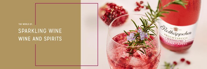 Close-up of a refreshing non-alcoholic fruit secco with pomegranate seeds and herbs.