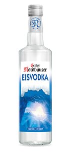 Eine klare Flasche mit Eiskristallen und blauer Etikette, die den Namen 'Echter Nordhäuser EISVODKA' trägt.