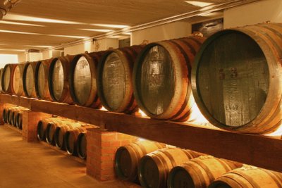 Nordbrand Nordhausen: A row of large wooden barrels stands on shelves in a well-lit wine cellar.