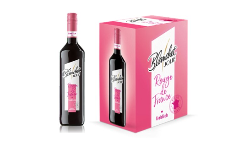 Eine Flasche Rotwein steht neben einer pinken Verpackung, die den Namen 'Rouge de France' trägt und ansprechend gestaltet ist.